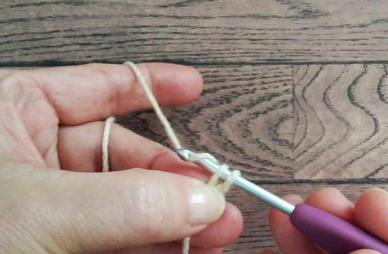 指で押さえて針に糸をかける画像