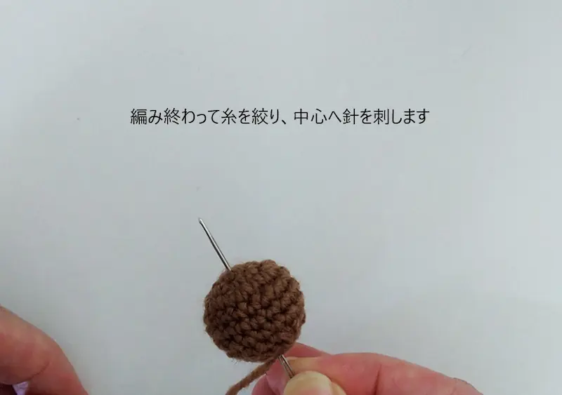 どんぐり本体を絞り終わったあと、中心から下(編み始め)に向かってとじ針を通しているところ